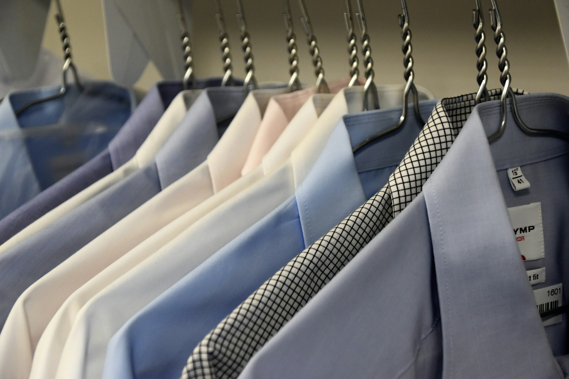 Rows of freshly dry-cleaned shirts and suits at Newham Dry Cleaners